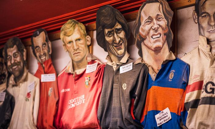 The photo shows hand painted heads of rugby stars with their shirts.